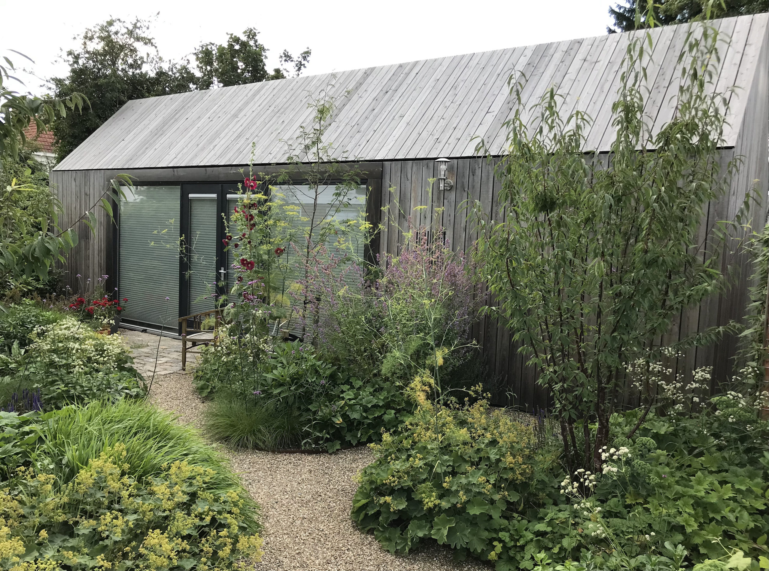 tuin bij atelier (ontwerp Onix-Architecten) rijk aan beplanting, heesters en vaste planten Tuinontwerp Tuinen van Thomas Caroline Thomas garden design